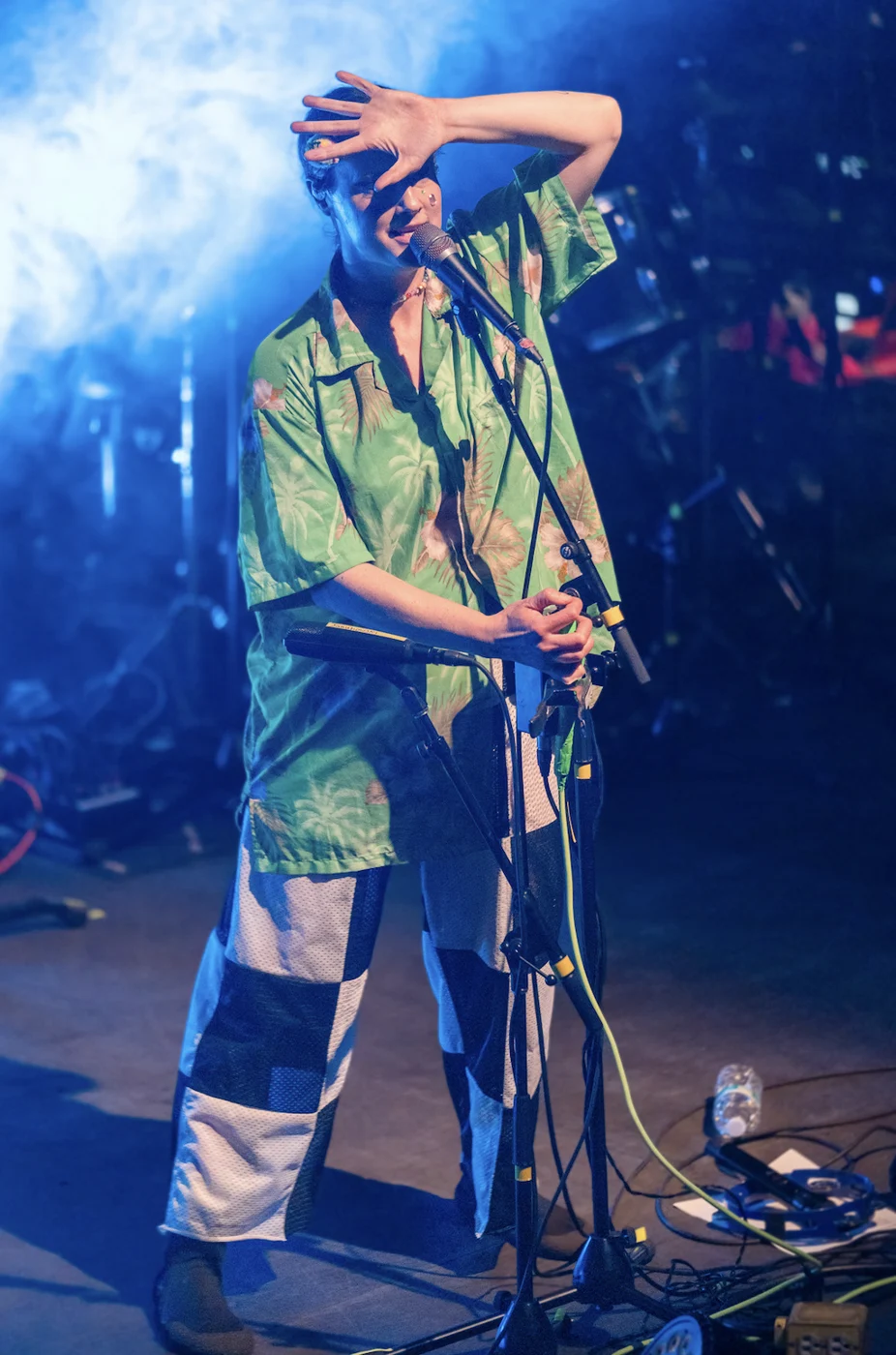 Live performance under blue stage lights, photographed by Tara Lenehan