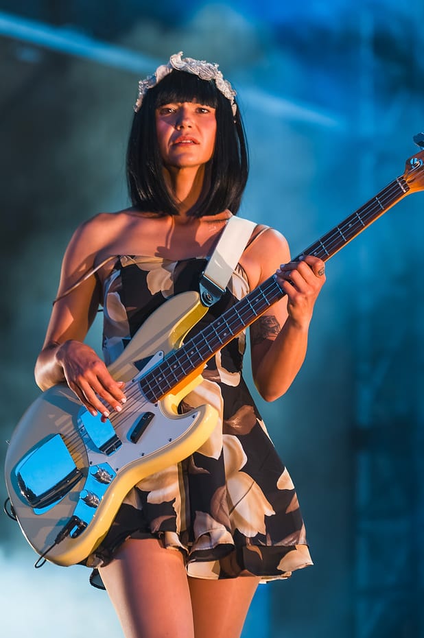 Khruangbin's bassist onstage in a floral dress under blue stage light at Outside Fest